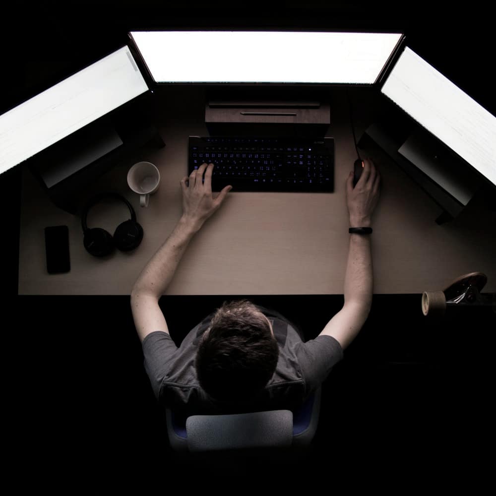 Escritorio visto desde arriba en una habitación a oscuras, con dos paneles de luz sobre el teclado